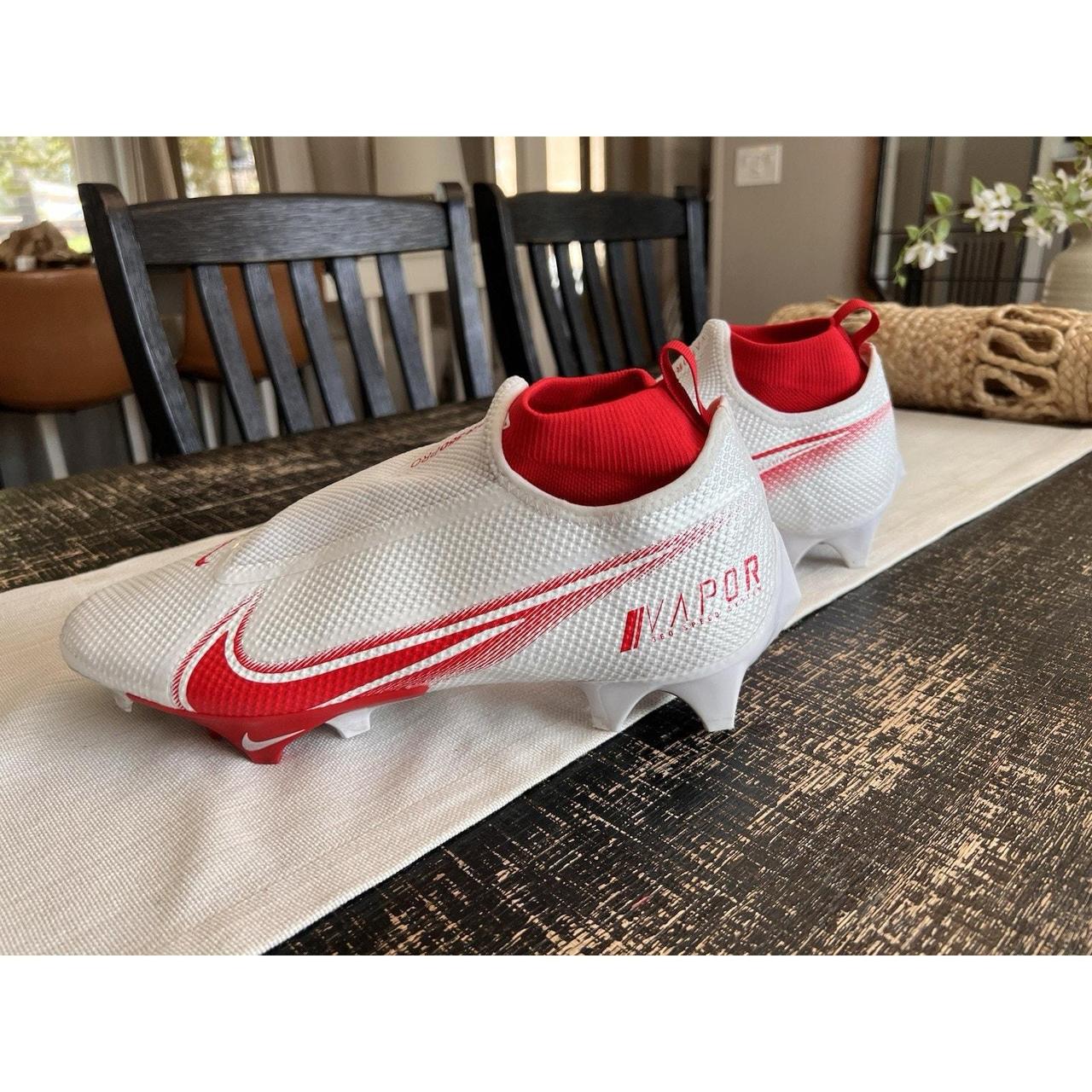 Nike Vapor football cleats in white and red, designed for speed and performance.